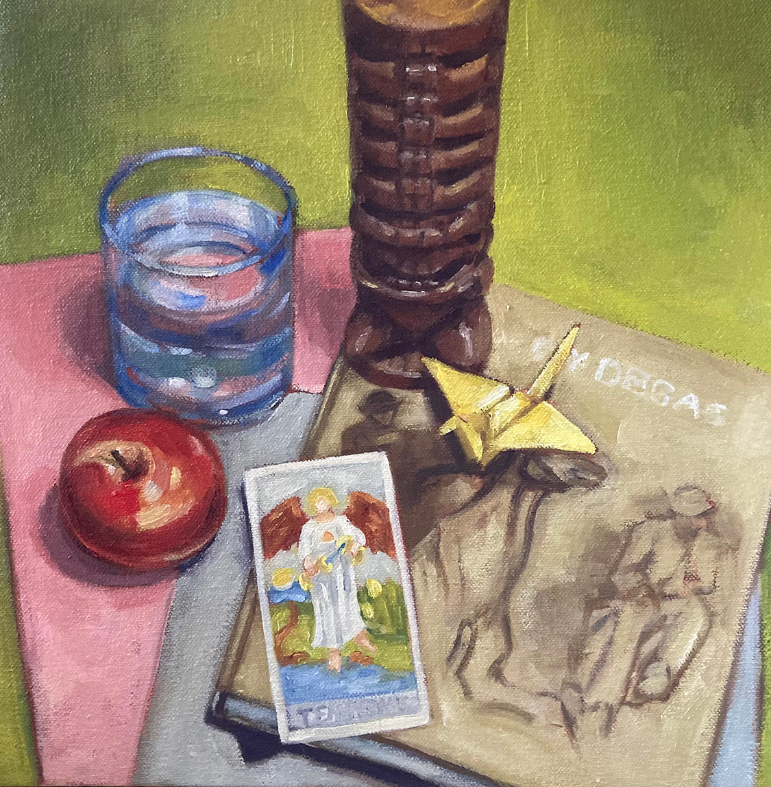 Oil painting still life of a book, the Temperance tarot card, a glass of water, a red apple, and a statue of the Hawaiian deity Kane on a green, pink and gray background.